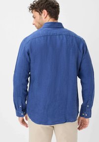 Blauwe linnen shirt met lange mouwen, knoopsluiting bij de manchetten en een zachte textuur. Heeft een klassieke kraag en een gebogen zoom.