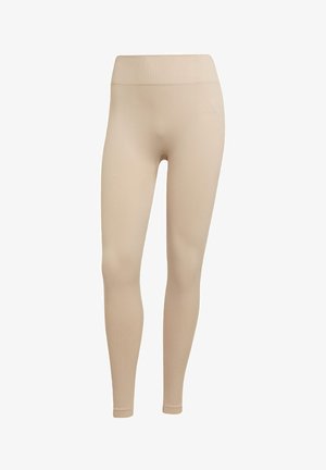 Beige legíny vyrobené z elastického materiálu s vroubkovanou texturou, s elastickým pasem a minimálními brandovými detaily.