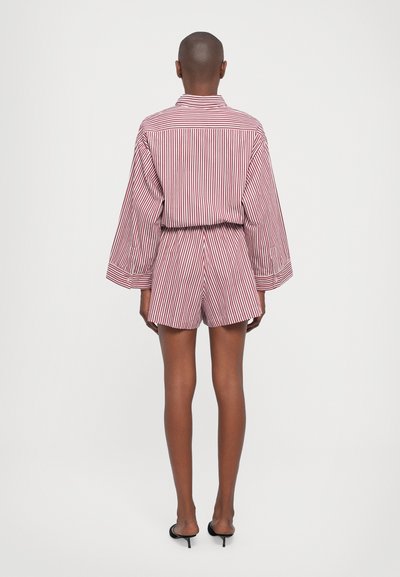 Red and white striped shirt and shorts set with a relaxed fit, featuring long sleeves and an elastic waistband. Worn with black heeled sandals.