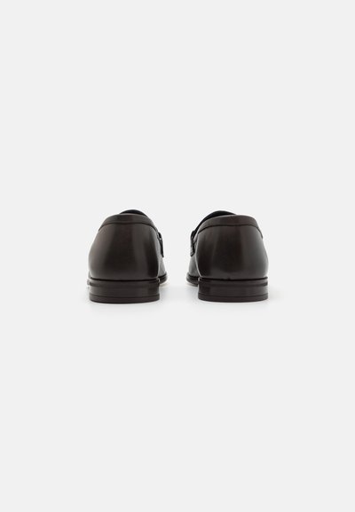 Czarne skórzane buty o gładkim wykończeniu, okrągłym nosku, niskim obcasie i minimalistycznym designie. Posiadają fason wsuwany z elegancką sylwetką.