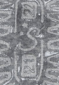 Gray textile featuring a woven pattern with embossed designs, showcasing a soft texture and contrasting lighter threads in intricate shapes.