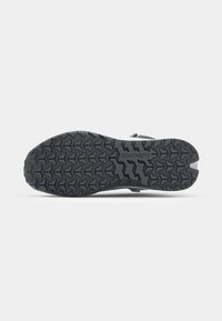 Gestructureerde zwarte rubberen schoenen zool met een diep loopvlakpatroon, voorzien van het merlogo en ontwerpaccenten voor verbeterde grip en duurzaamheid.