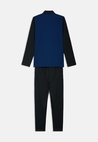 Μπλούζα μακρυμάνικη σε ναυτικό μπλε με μαύρη βάση, συνδυασμένη με μαύρο παντελόνι. Λείο ύφασμα, απλός σχεδιασμός και casual εφαρμογή.