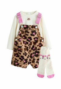 Braune Cord-Overalls mit schwarzen und rosa Leopardenflecken, rosa Trägern, einem weißen Langarmoberteil und cremefarbenen Socken mit pinkem Mausdesign.