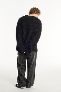 Black fuzzy sweater with long sleeves, relaxed fit, and textured surface; paired with dark, wide-leg jeans. Simple design and monochrome colors.