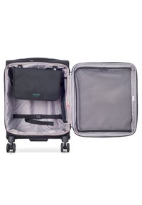 Valigia rigida nera con interni viola, dotata di una tasca in rete con cerniera, cinghie per fissare gli oggetti e un ampio scomparto per il confezionamento.