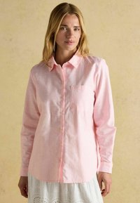 Svetloružová košeľa na gombíky so vzorom kociek, s dlhými rukávmi, zaobleným lemom a vreckom na hrudi, vyrobená z ľahkého materiálu.