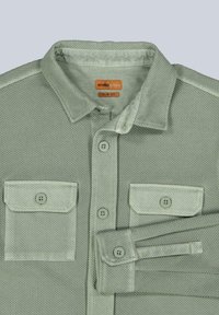 Slim fit, green shirt made of textured fabric featuring a button-down collar, two chest pockets, and matching button accents.