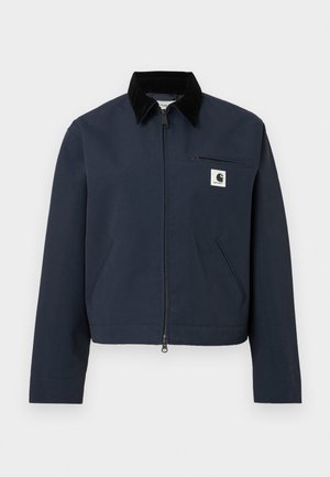 Jachetă zip-up de culoare albastru marin cu guler negru, două buzunare frontale, buzunar pe piept cu fermoar și patch logo alb în formă de pătrat pe piept.