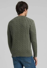 Maglione verde a trecce con scollo rotondo e polsini a costine. Il motivo strutturato valorizza un design accogliente e un colore uniforme.