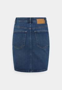 Dunkelblaue Jeanshose mit taillierter Form, fünf Taschen und einem braunen Lederpatch am hinteren Bund. Saubere Nähte und glatte Textur.