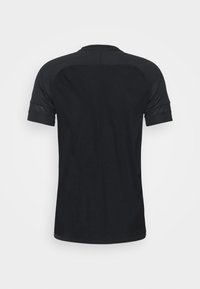 Camiseta negra de manga corta hecha de un tejido transpirable, con cuello redondo y textura suave, presentando un diseño sutil y sin costuras.