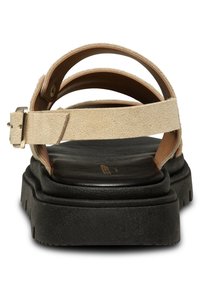 Beige suede sandals with three straps, a buckle closure, and a thick black platform sole. Interior features a smooth tan leather lining.
