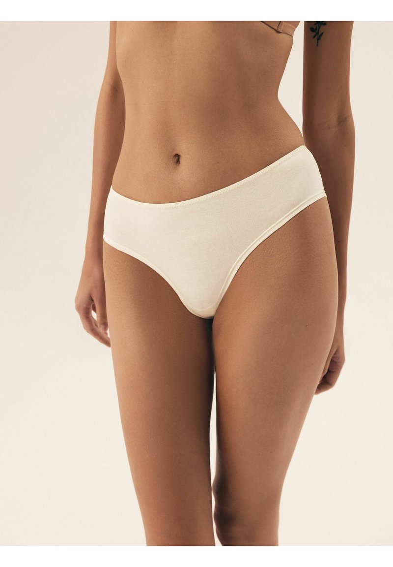 Beżowe bawełniane figi hipster z gładkim, bezszwowym wykończeniem oraz elastycznym pasem, charakteryzujące się standardowym krojem zapewniającym odpowiednie zakrycie.
