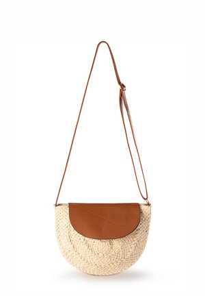 Woven straw crossbody bag o okrągłym kształcie, z brązową skórzaną klapą i regulowanym skórzanym paskiem, prezentująca teksturowane wykończenie.