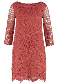 Robe en dentelle couleur rouille avec des motifs floraux, manches trois-quarts transparentes et ourlet festonné, dotée d'un col rond.