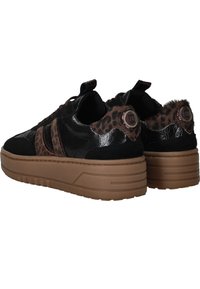 Des baskets noires et brunes avec une tige brillante ornée d'imprimés léopard, un tissu texturé et une semelle épaisse en caoutchouc beige.