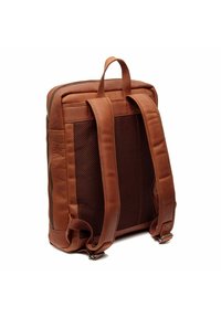 Mochila de cuero marrón con respaldo de malla acolchada, cierre con cremallera, dos correas ajustables y un asa superior para llevar. Detalles de costura sutiles visibles.