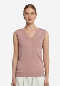 Ärmlös topp med V-ringning i mjukt rosa stickat tyg. Har ribbad nederkant och armhålser. Lätt textur med subtil lyster.