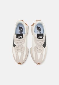 Light grey sneaker with white and black accents, textured upper, round laces, and rubber outsole. Features logo on tongue and insole.