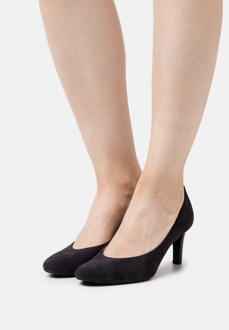 Black suede high-heeled pumps with a smooth texture, rounded toe, and a 3-inch heel. Sleek design emphasizes a classic silhouette.