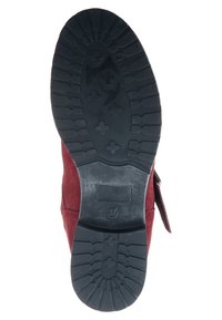 Botte en daim rouge avec une semelle en caoutchouc noir texturée présentant une bande de roulement à motifs. Vue latérale montrant un détail de sangle. Taille indiquée : 37.