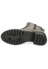 Bruine leren enkellaars met zwarte rubberen zool, voorzien van een gestructureerd loopvlak en een zijrits voor gemakkelijk aan- en uittrekken. Aangevuld met metalen studs.