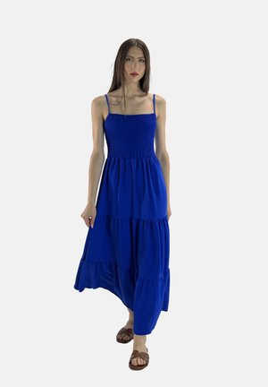 Robe maxi bleu royal avec fines bretelles spaghetti, corsage froncé et ourlet à volants en tiers. Tissu léger avec une silhouette fluide.