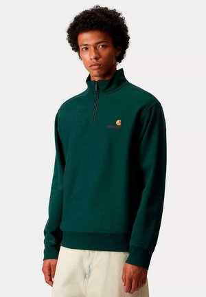 Suéter de forro polar verde con un cuello de media cremallera, que presenta un logo bordado en el pecho y puños y dobladillo acanalados. Textura suave.