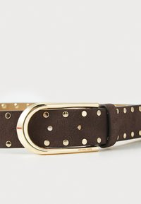 Brown suede belt with gold hardware, featuring circular studs and a rounded buckle. Brand name "Michael Kors" embossed on the buckle.