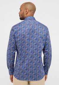 Langemouwen overhemd met een blauw en gouden bladenpatroon, met een knoopsluiting op de kraag en een gladde stoftextuur met een getailleerde pasvorm.