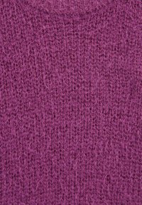 Élénk lila kötött anyag laza, texturált szövettel és látható szálakkal, amelyek puhának és kényelmesnek tűnnek.