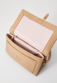 Borsa in pelle color tan con esterno testurizzato, foderatura interna rosa e tasca frontale. Caratterizzata da una cerniera e una tracolla in tonalità oro.