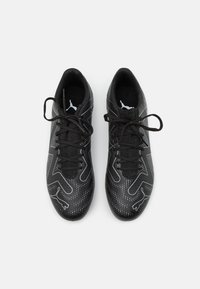 Zapatillas deportivas negras con un upper texturizado, que presenta un diseño estampado y acentos blancos. Diseño de cordones con un collar acolchado para mayor comodidad.