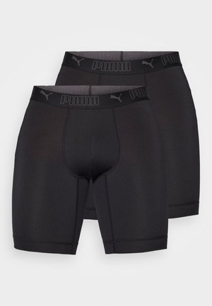 Pantalones cortos deportivos negros de Puma con una cinturilla que presenta el logo de la marca, hechos de tejido elástico, con una textura suave y de longitud media en los muslos.