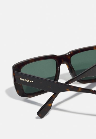 Occhiali da sole Burberry con montatura in acetato tartarugato, lenti verdi e branding dorato sulle tempie. Forma rettangolare elegante e texture liscia.