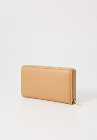 Portafoglio in pelle beige con superficie testurizzata, forma rettangolare e chiusura con zip dorata. Nessun logo o decorazione visibile.