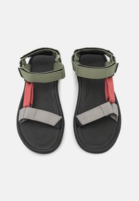 Black sandals with three adjustable straps: olive green, grey, and red. Textured footbed, lightweight design, durable material.