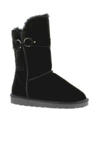 Black velvet mid-calf boot featuring a decorative belt with a circular metal accent and a soft, fur-lined top edge. Flat rubber sole.