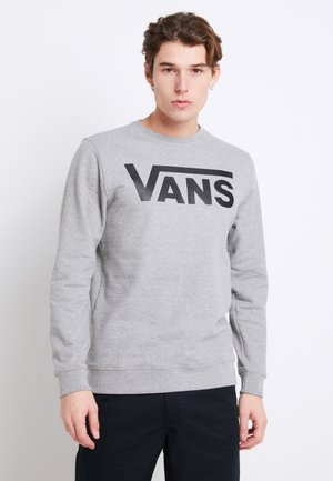 Sudadera gris de manga larga, con un destacado logo negro de "VANS" en el pecho. Puños y bajo acanalados. Textura suave.