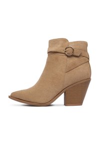 Beżowy zamszowy botek za kostkę z szpiczastym noskiem i owiniętym paskiem z okrągłym akcentem. Maszty, karbowany obcas dla stabilności.