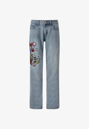 Vaaleansiniset farkut, joissa on elämäniloinen brodeerattu kuvasto värikkäästä kalasta ja kieppuvista aalloista vasemmassa lahkeessa.