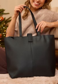 Zwarte handtas gemaakt van een gladde stof, met twee lengterichting handgrepen en een bovenklep sluiting. Eenvoudig ontwerp zonder zichtbare bevestigingsmiddelen.