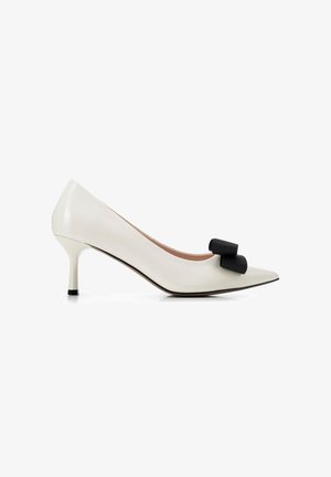 Witte pumps voor dames met een puntige neus, een mid-height naaldhak en een zwarte decoratieve strik aan de voorkant.