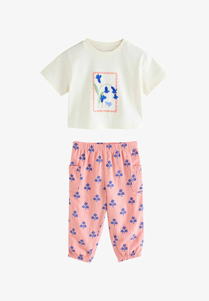 Short-sleeve cream crop top with blue floral print and pink elastic waist pants with blue flower patterns and side pockets.