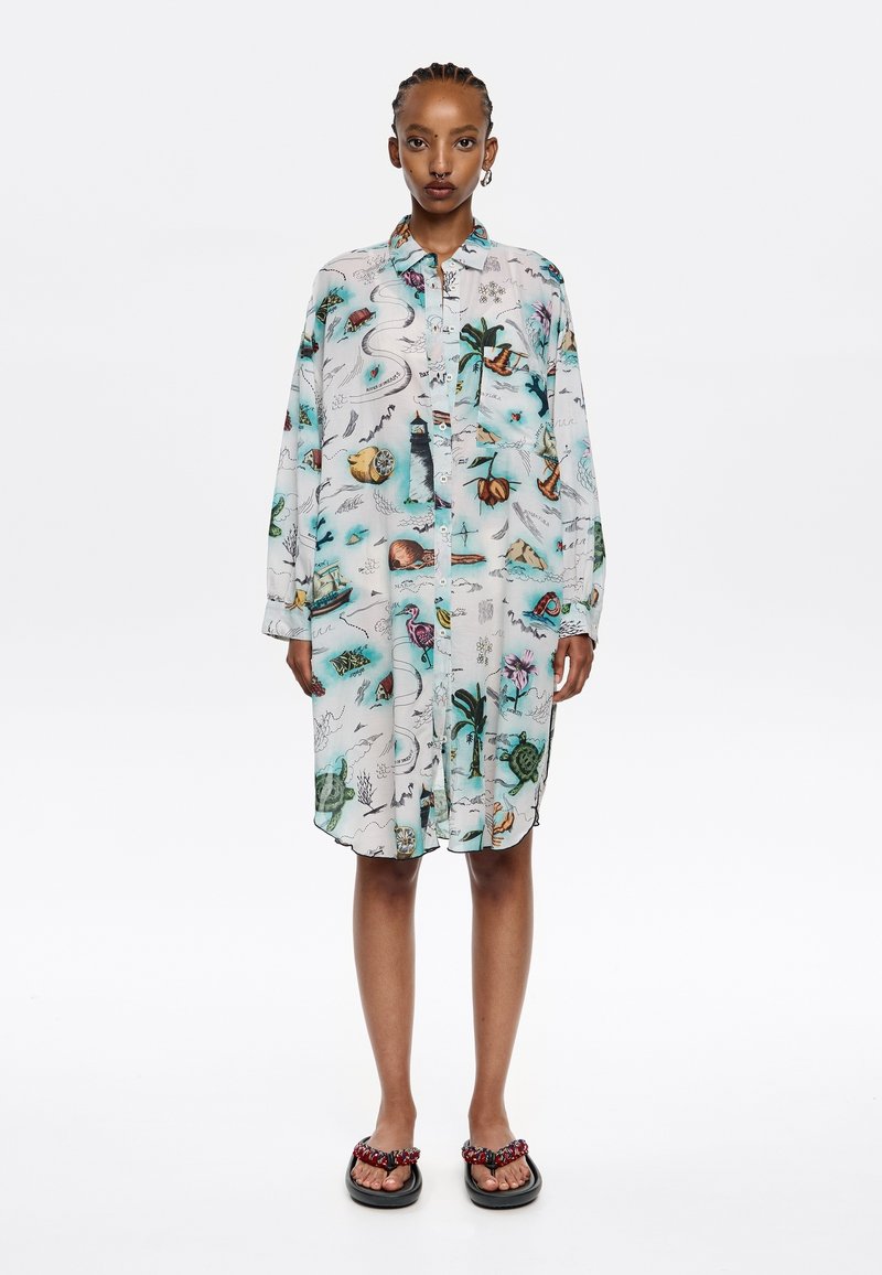 Abito camicia con bottoni in tessuto leggero e trasparente, caratterizzato da una stampa colorata a tema naturale. Maniche lunghe, orlo curvo e vestibilità rilassata.