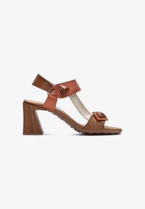 Sandalia de tacón marrón y naranja con correas texturizadas, acentos triangulares y un tacón de bloque de madera. Diseño de punta abierta con correas ajustables.