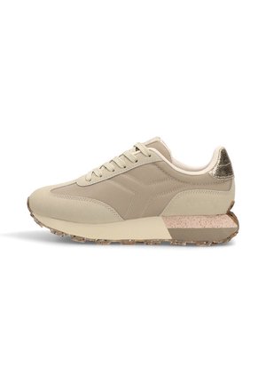 Zapatilla deportiva beige con parte superior de cuero suave, acentos texturizados y suela moteada. Presenta un collar acolchado y cierre de cordones.