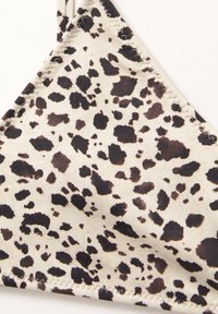 Tissu à motif léopard en beige avec des taches noires, présentant une forme triangulaire et des coutures propres le long des bords. Texture douce avec élasticité.
