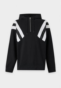 Sweat à capuche noir avec une fermeture éclair à mi-hauteur et des rayures diagonales blanches et noires sur le haut des manches et la poitrine.